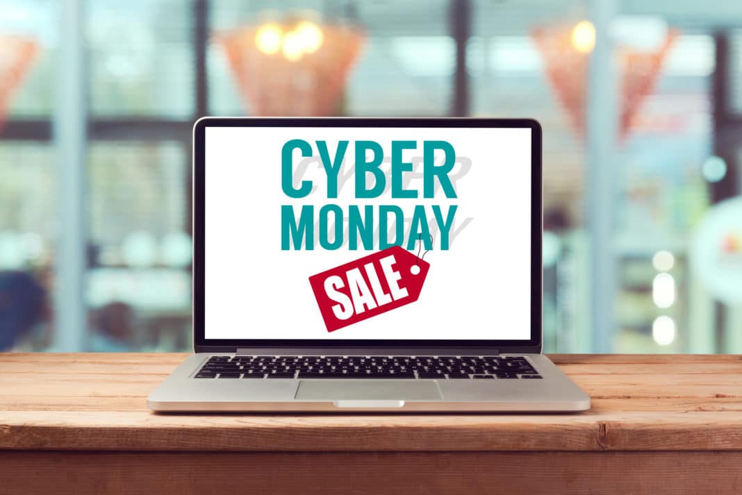 A laptop on a table with a screen that reads "cyber monday sale."
