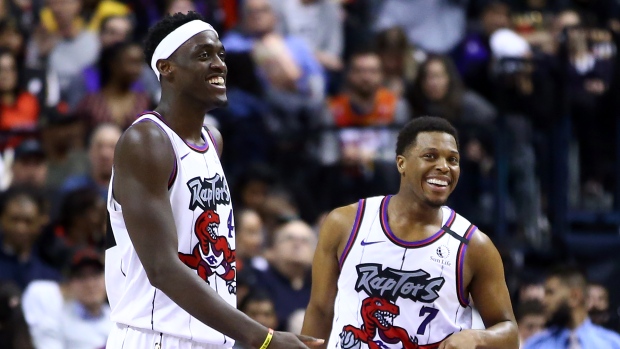 Kyle Lowry and Pascal Siakim sharing a laugh on the basketball court