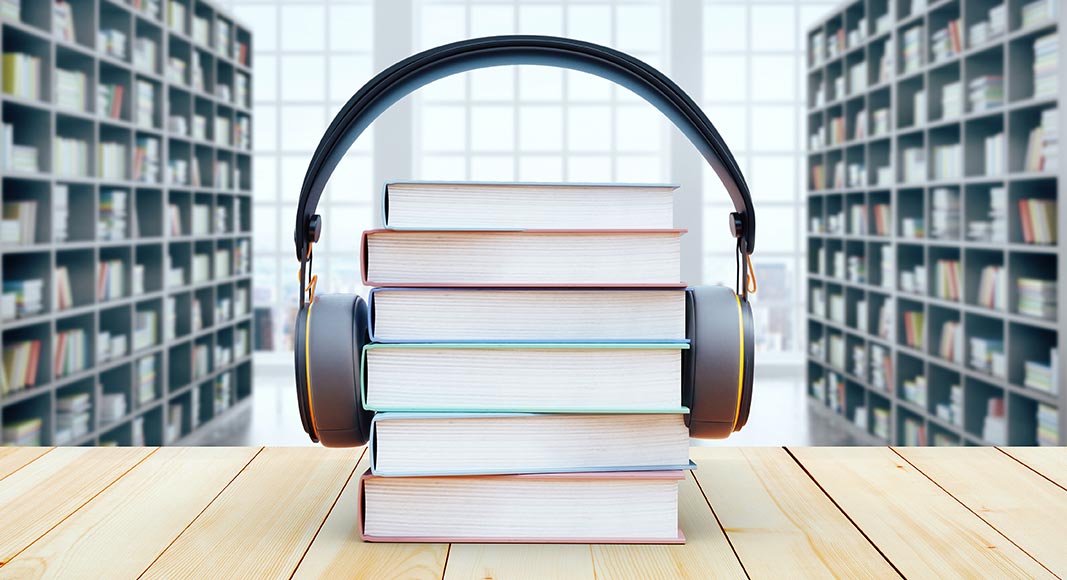 A stack of books with headphones on top