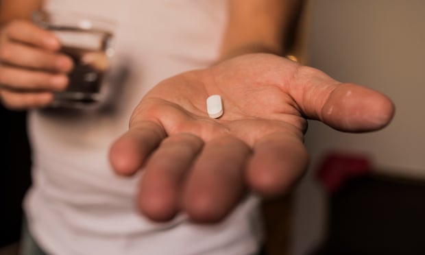 A closeup of a person's hand holding a pill.