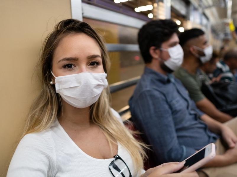 People sitting in a waiting room wearing masks