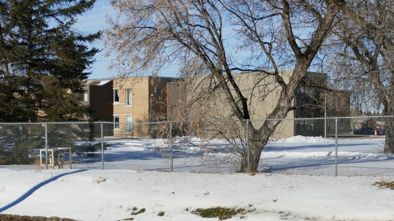 An exterior photo of the Manitoba Developmental Centre surrounded by trees in the winter. 