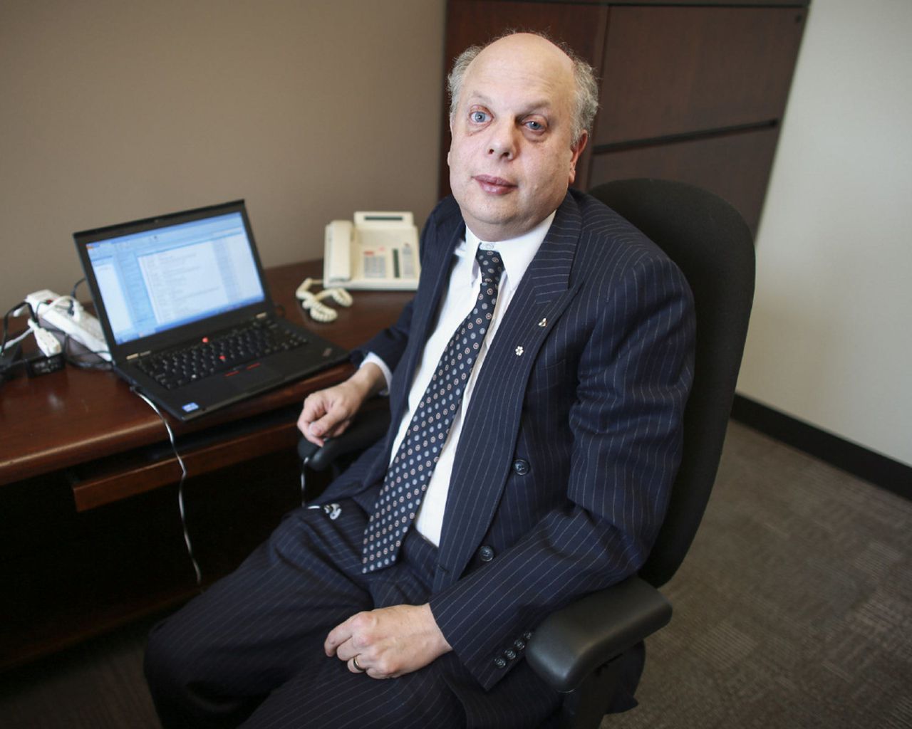A photo of David Lepofsky in a suit at an office desk.