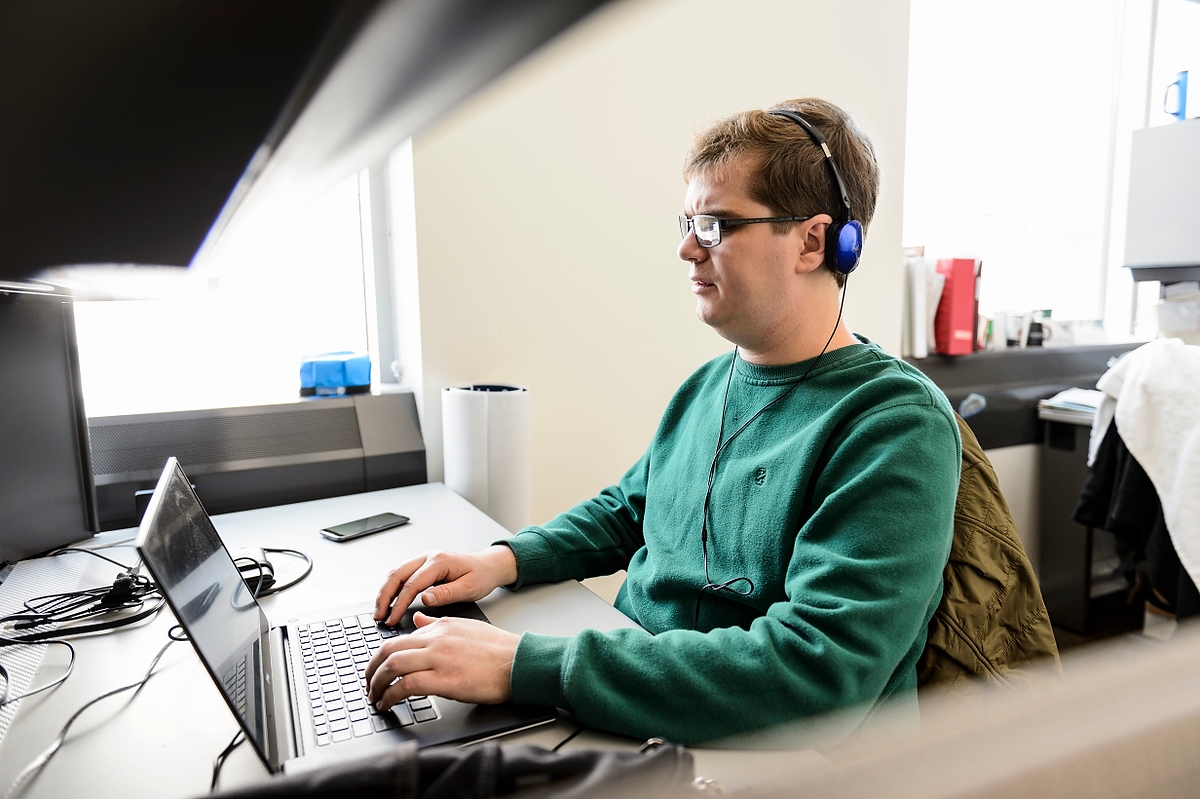 A user who is blind uses a laptop computer wearing headphones. 