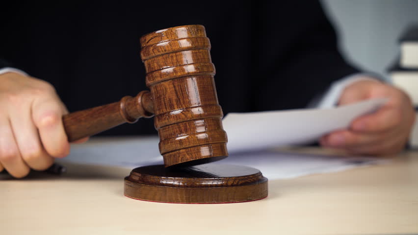 A closeup of a judge slamming down a gavel. 