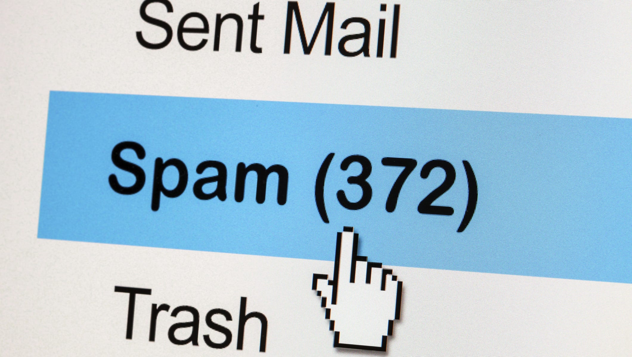 A closeup of a computer cursor hovering over an email inbox that reads "spam."