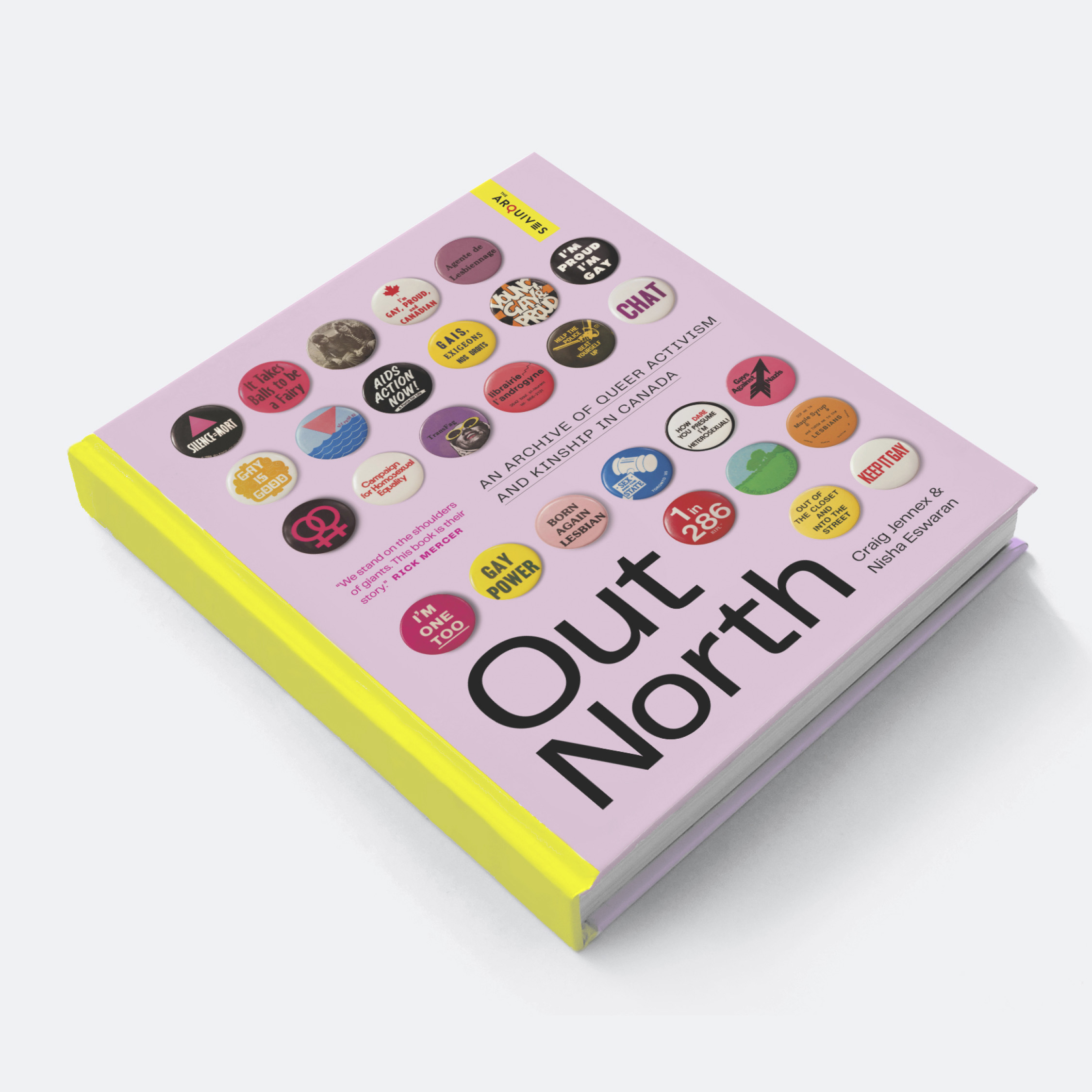 A pink book cover on a table with images of button with various slogans. The title of the book reads "Out There."
