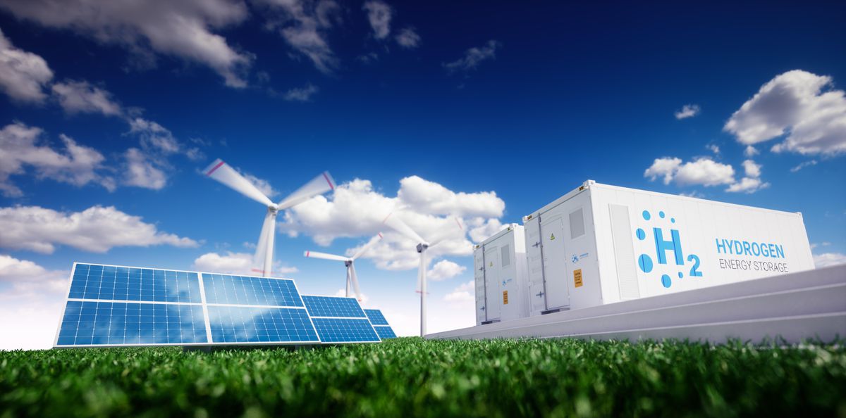A field of solar panels and wind mills with two hydrogen trailers on the side. 
