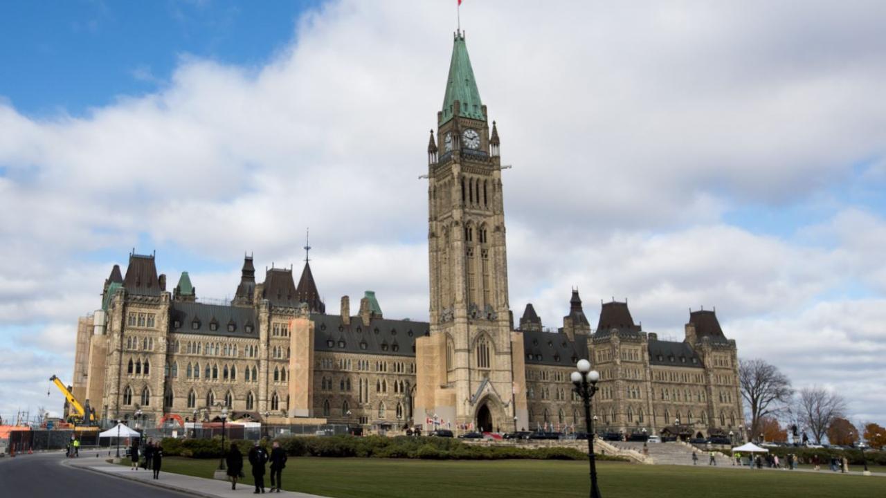 A photo of Canada's parliament building in Ottawa with a blue sky in the background. 