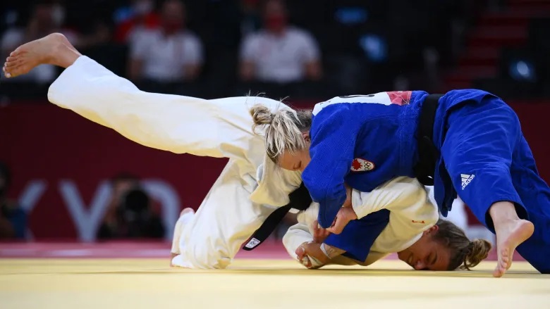 Canada's Jessica Klimkait, in blue, and Slovenia's Kaja Kajzer, in white, tackl each other on the ground in the judo women's under-57 kg bronze medal bout during the Tokyo Olympic Games.