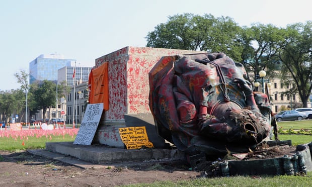 A headless statue of Queen Victoria is seen overturned and covered in red paint with red hand prints at the provincial legislature in Winnipeg.