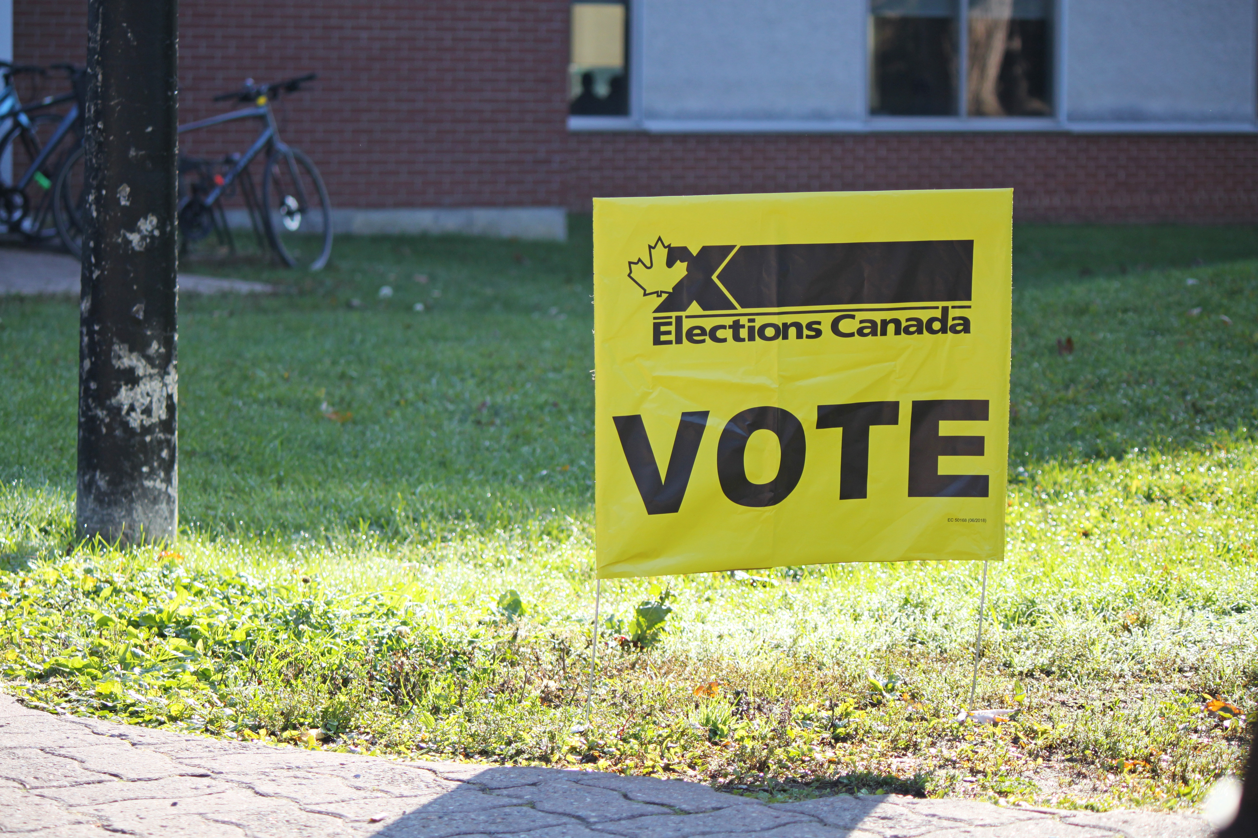 A yellow sign outside a school that reads "Elections Canada VOTE"