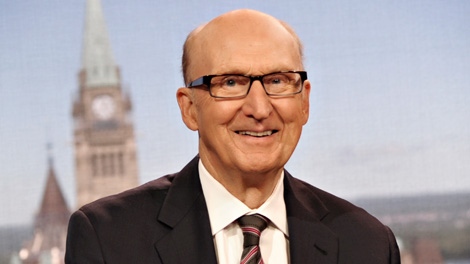 A photo of Craig Oliver smiling in a suit with glasses. 