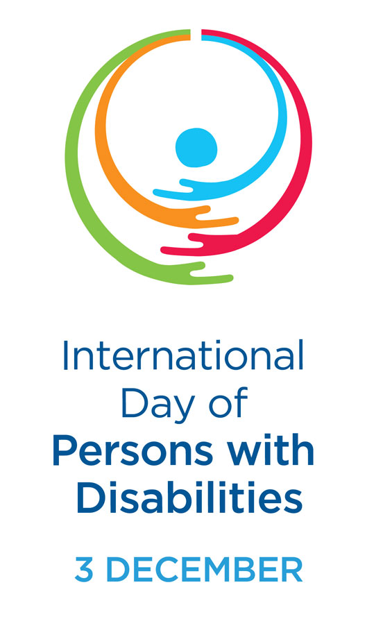The official logo for UN's International Day of Persons with Disabilities. 2 December. There is also a circicular graphic of different colours of arms curving as if they are hugging. In the centre is a blue circle in the centre of the arms. 