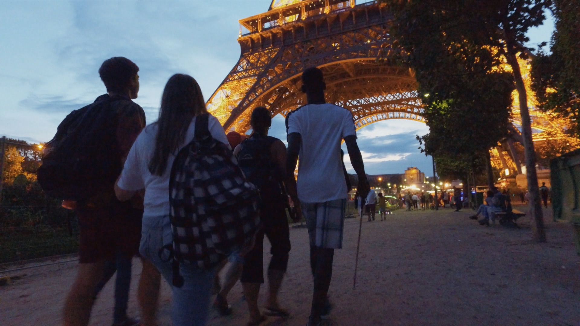 À la nuit tombante, les jeunes arrivent au pied de la tour Eiffel