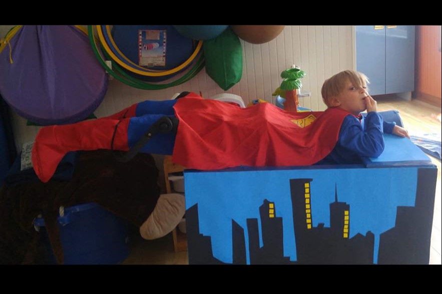 Superman qui vole, avec des fausses jambes déposées sur le fauteuil roulant 